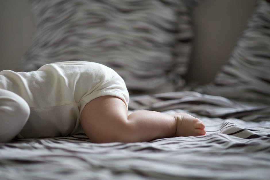 Sweet image of a baby resting peacefully on a cozy bed in soft lighting.