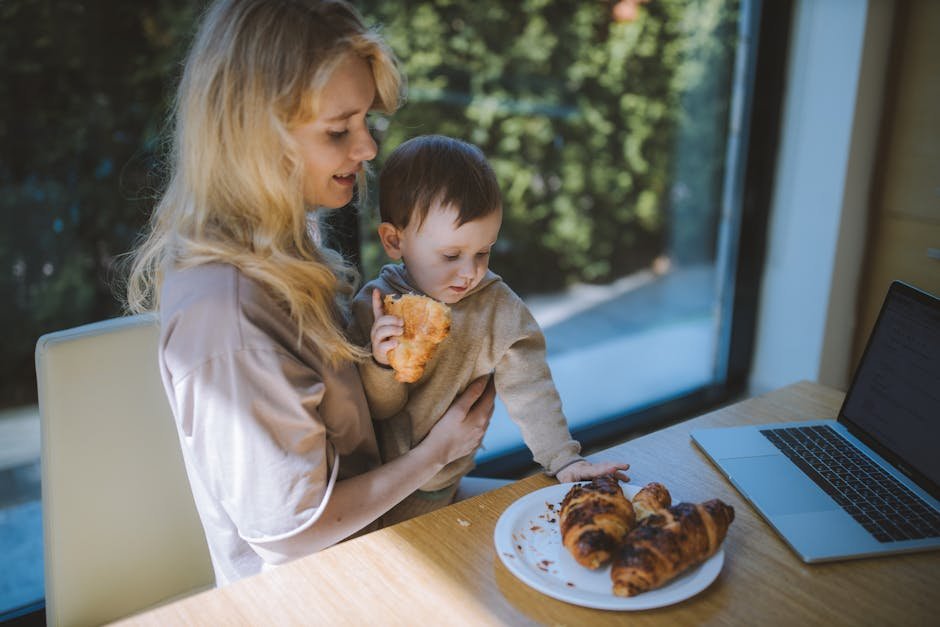 A mother and child share a joyful breakfast with croissants, embodying family togetherness at home.