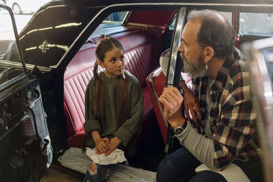 Father and young daughter share a moment inside a vintage car, highlighting family togetherness and nostalgia.