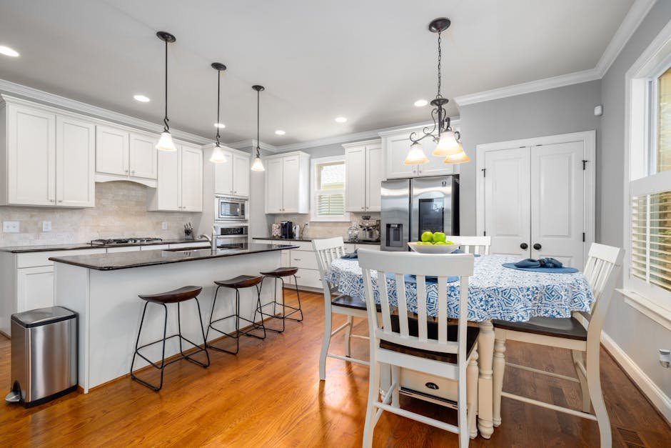 Spacious and elegant kitchen interior featuring a dining table and modern appliances, perfect for family gatherings.